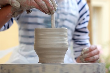 Fototapeta na wymiar Children Potter's hands creating new vase