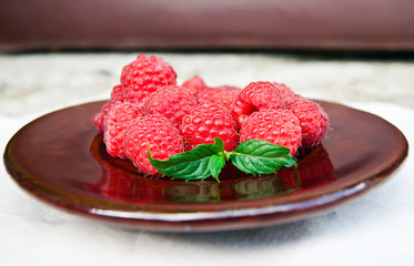 Fresh organic raspberry in plate. Selective focus