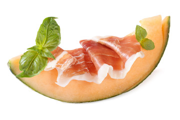 slice of melon with ham and basil isolated on white