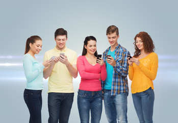 group of smiling teenagers with smartphones