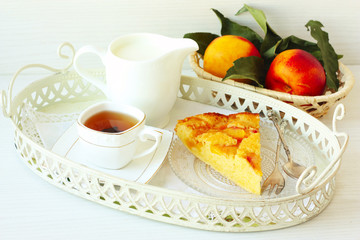 white breakfast with homemade peach pie, tea, milk and fresh fr