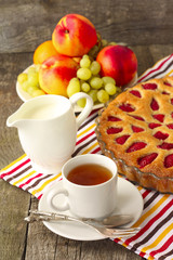 strawberry cake with tea, milk and fruit for breakfast