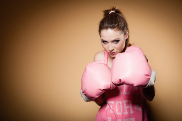 Female boxer wearing big fun pink gloves playing sports