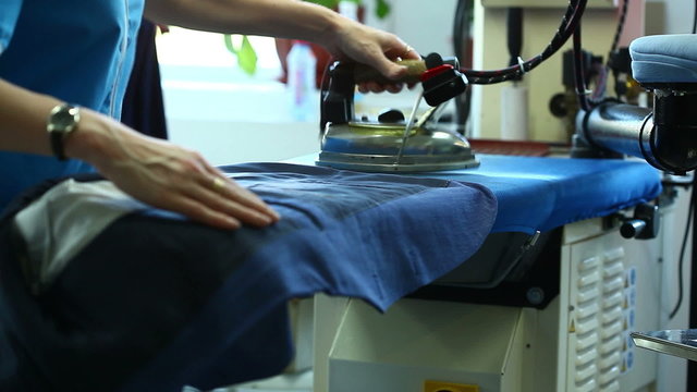 Woman ironing and steaming jacket, close-up