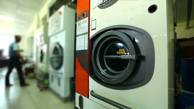 Worker checks washing machines in laundry room
