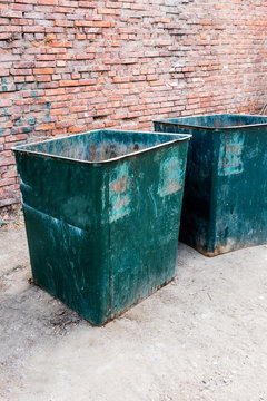Angle vertical view of a two green dustbins outside against red