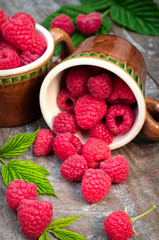 Red ripe raspberries on a wooden background