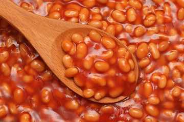 Baked beans in a wooden spoon