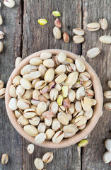full bowl of pistachio on wooden surface
