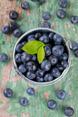 fresh blueberries in a bucket on wooden surface