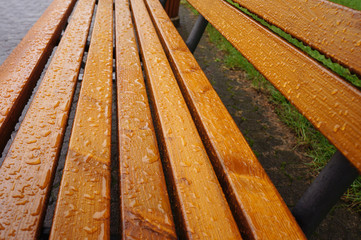 Holzschutzlack auf einer Parkbank aus Echtholz bei Regen