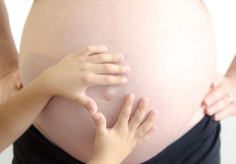 madre incinta con mani figlio sulla pancia