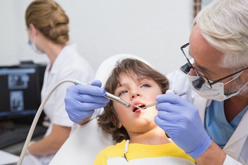 Pediatric dentist examining a little boys teeth