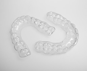 Translucent upper and lower essix retainers on a gray background
