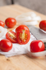 Red small tomatoes on wood board.