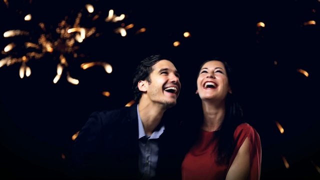 young couple enjoying new year's eve fireworks