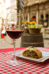 glass of red wine and a tasty food on a table outdoors