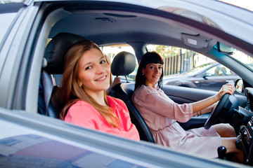 Two young and beautiful woman sitting in the car