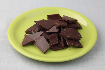 Pieces of chocolate on a green plate