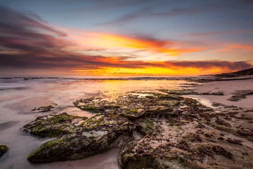 Gordijnen beautiful beach rock under sunset © photofancy