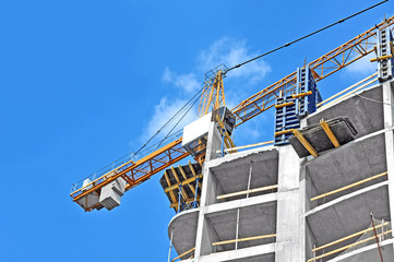 Fototapeta premium Crane and building construction site against blue sky