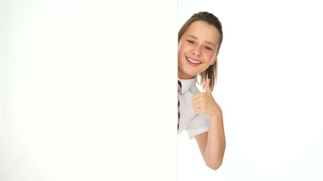 Young girl peering around the edge of a sign