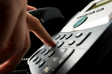 Person dialing out on a landline telephone