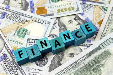 word finance on wooden cubes on american dollars background