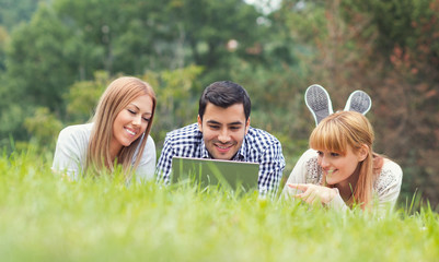 Friends have fun and study homework on laptop