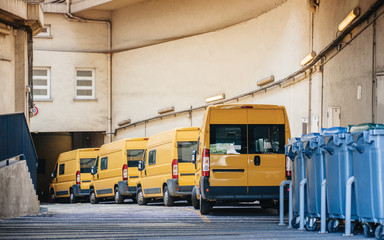 Yellow delivery vans trucks distribution in warehouse center