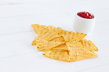 Nachos with salsa sauce on white table