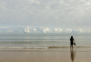 Fototapeta na wymiar Mujer paseando por la orilla de la playa