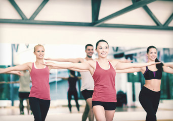 Fototapeta na wymiar group of smiling people exercising in the gym