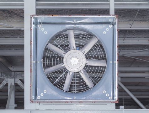 Industrial exhaust fan installed inside factory, featuring metal housing, blades, ventilation system, air circulation, cooling equipment, hvac engineering, manufacturing facility, airflow control.