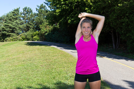 Fit woman stretching her muscles before running