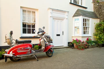 Foto op Canvas Rode vintage scooter geparkeerd voor Engels huis © mubus