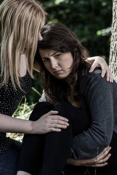 Woman hugging her worried friend
