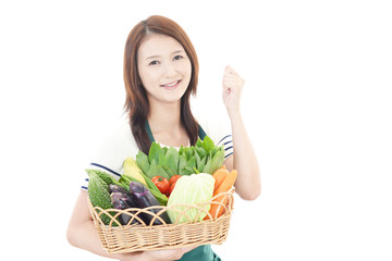 野菜を持つ笑顔の女性