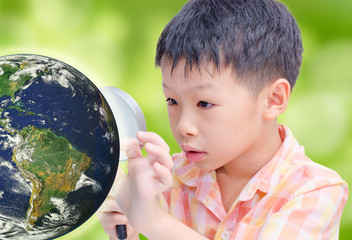 Asian boy looking at glowing globe by magnifying glass, Elements
