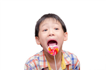 little Asian boy eating candy in his hand, isolated on a white b