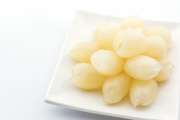 Rambutan is cored on white plate.