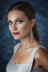 Beautiful elegant woman with evening make-up and long earrings