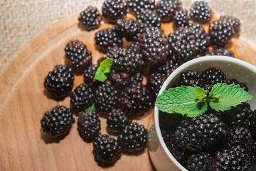Blackberries with mint  in cup and wooden table