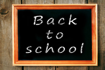 Back to school. The frame on wooden background.