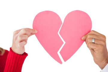 Couple holding two halves of broken heart