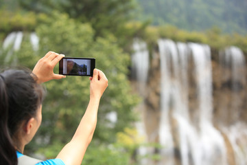 young woman tourist taking photo with smart phone outdoor