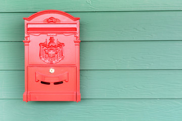 Red mailbox with green wood background