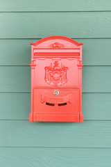 Red mailbox with green wood background