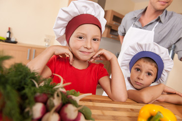 Portrait of parents and two children making food.