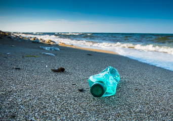 Pollution and waste on the beach in sunset light